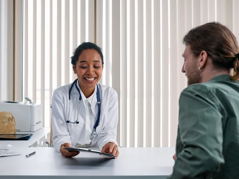 Doctora conversando con un paciente en su consultorio